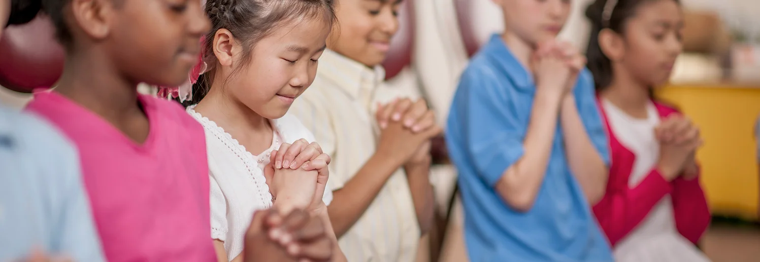 Kids praying in church.
