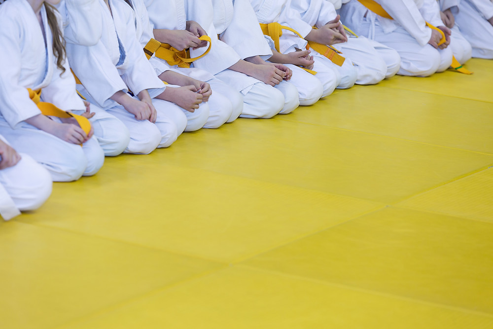 Karate yellow belts on yellow mats