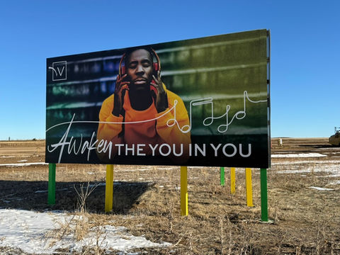 Billboard with a man wearing headphones and the text "Awaken the You in You".