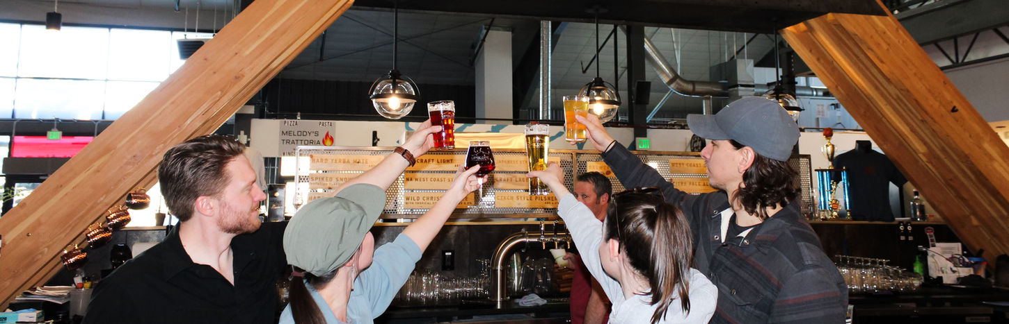Four people toasting with drinks at Upslope Brewing