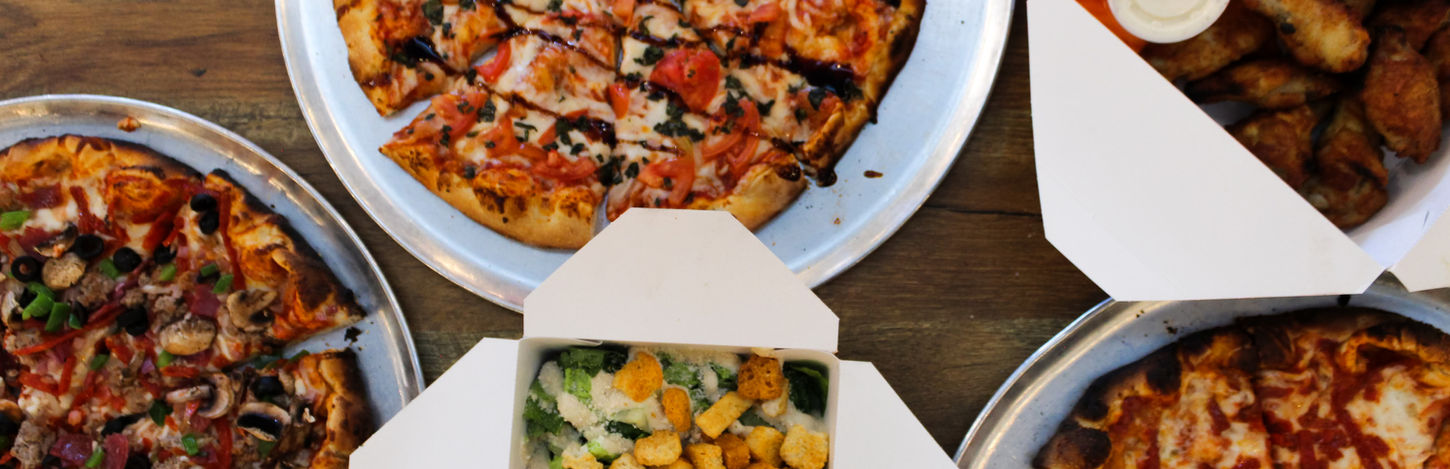 Three pizzas, wings, and a chicken salad takeout meal