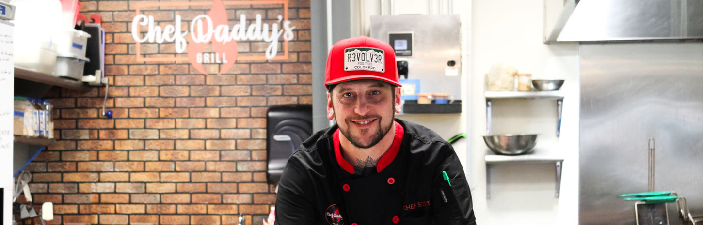 Smiling chef from Chef Daddy's Grill presenting two burgers