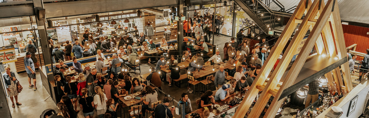 Bustling multi-level market hall with many diners