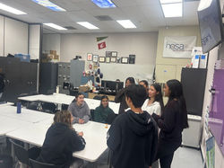 Members Arundhathi Jathin and Hudson Lee interact with students during chapter presentation.