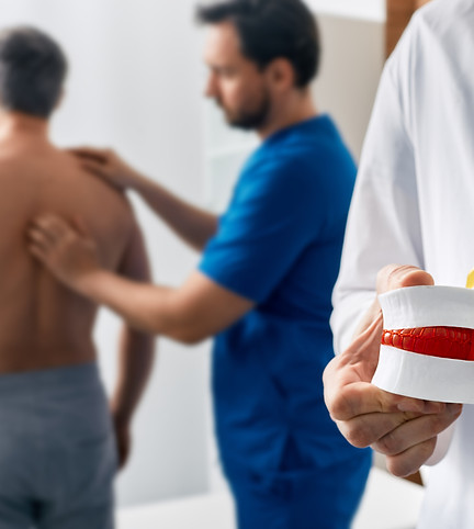 Chiropractor rubbing man's back