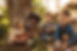 Group of cute kids sitting together in forest and looking at camera. Cute children playing