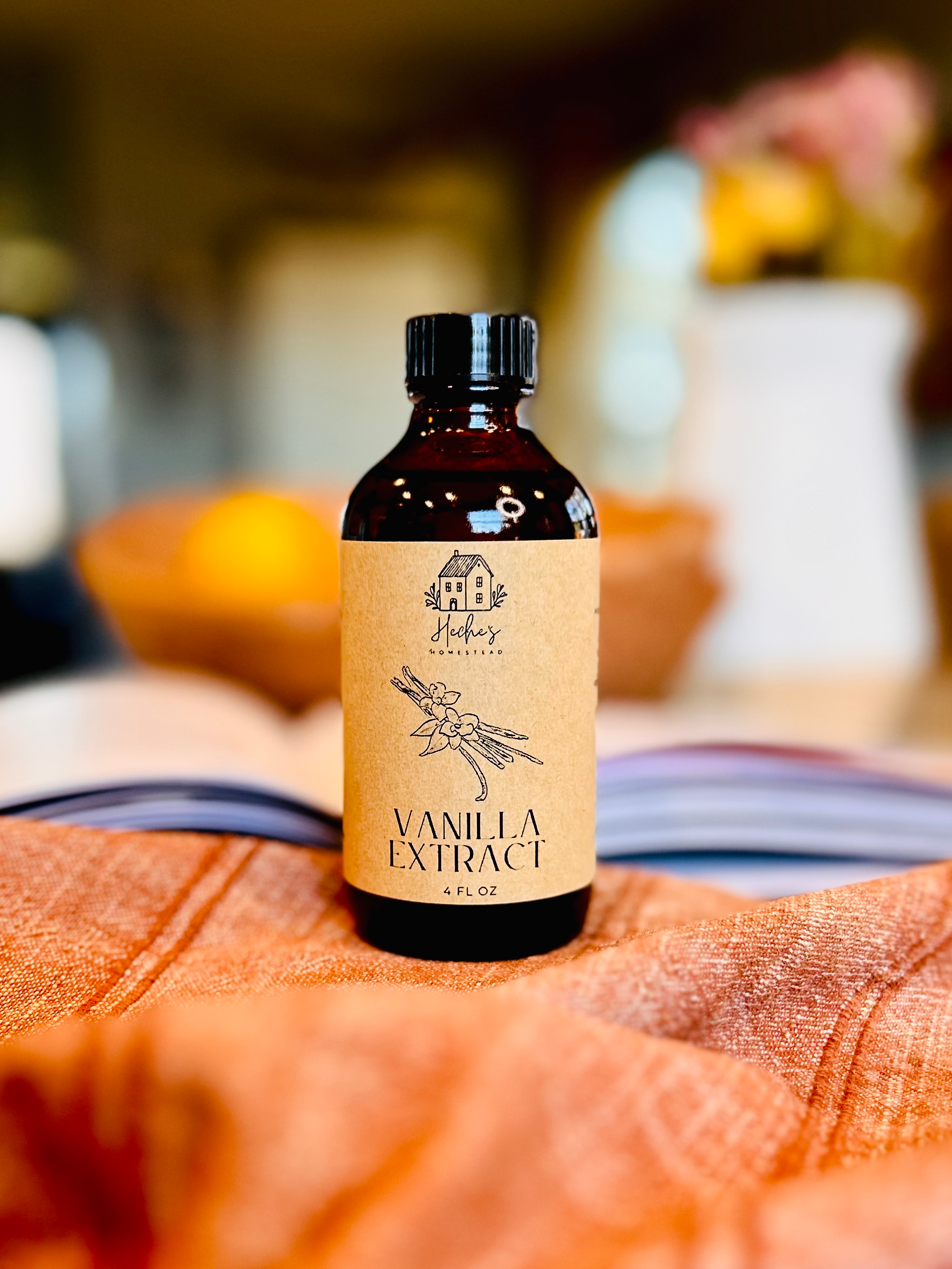 amber jar filled with vanilla extract sitting on a red tea towel in a farmhouse kitchen