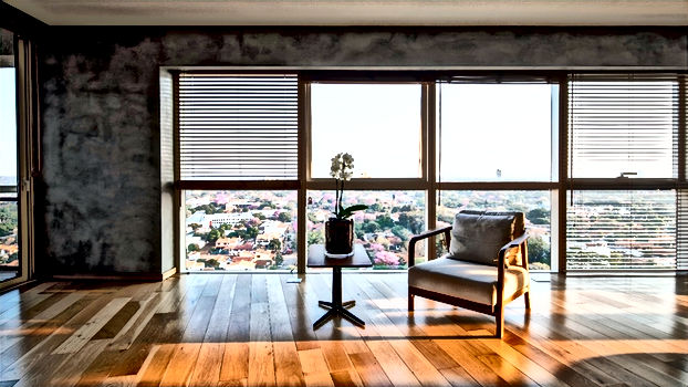 Interior view with chair, table, blinds, city view, and wood floor. M2 Inmobiliaria.