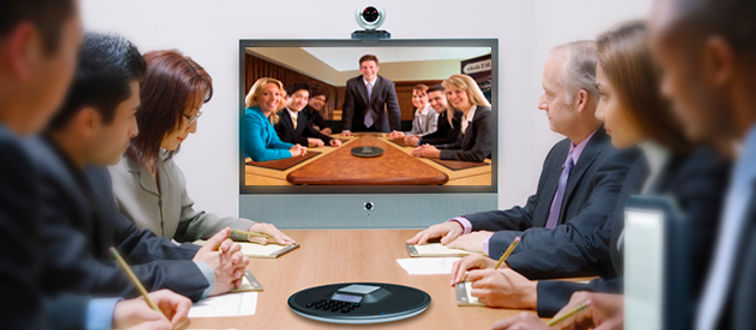 Business people during video conference sitting around conference table