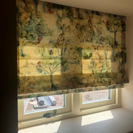 Floral pattern roman blind at window, sunlight through, indoors. EYE 4 DESIGN