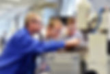 Instructor guiding students using industrial machinery in a technical training workshop