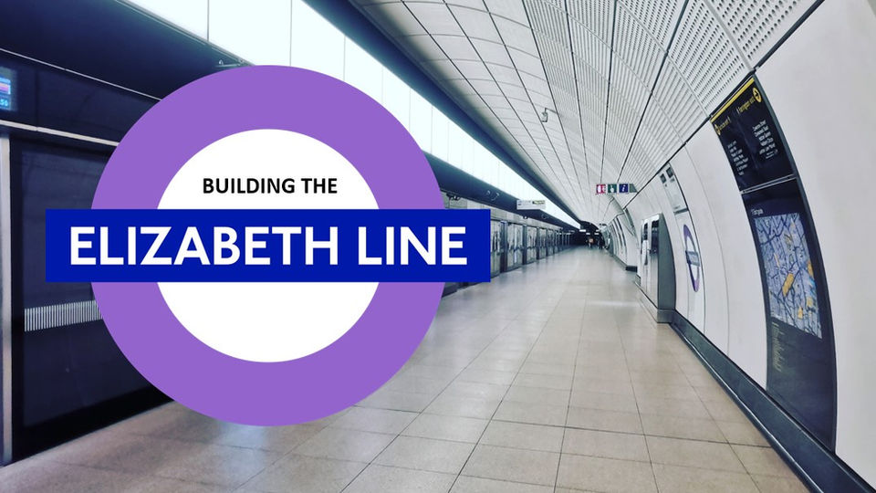 Long bright white Elizabeth Line underground train platform, purple London Transport roundel with the words Building The Elizabeth Line.