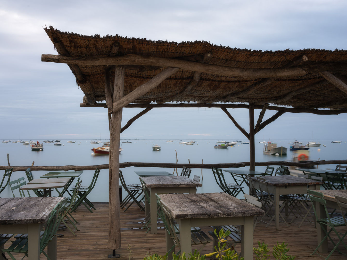 Holzpfähle und Restaurant im Bassin bei Cap Ferret, Frankreich
