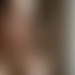 A woman with a thoughtful expression holds her finger to her lips, signaling silence.