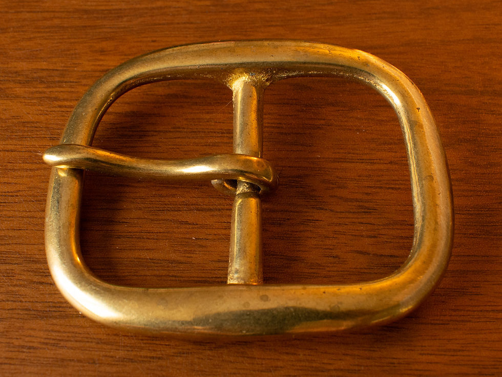 A solid brass buckle put to the same test and showing it has held up much better.
