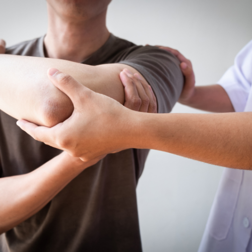 Chiropractor assessing a patient's shoulder, using manual techniques to treat a rotator cuff injury in a clinical setting.