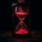 Black hourglass with glowing red sand, digital symbols flowing into it, on dark cracked surface, creating a mysterious, digital mood.