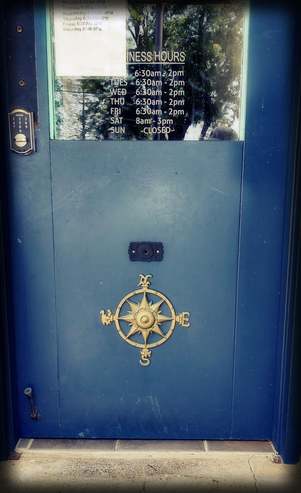 Front door of local coffee shop with compass
