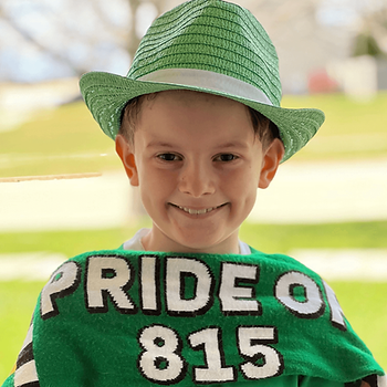 Introducing Our Newest MVP: William Matthiesen, Director of Soccer Shenanigans! A young boy proudly wearing a green shirt and hat with the words "pride of 815".