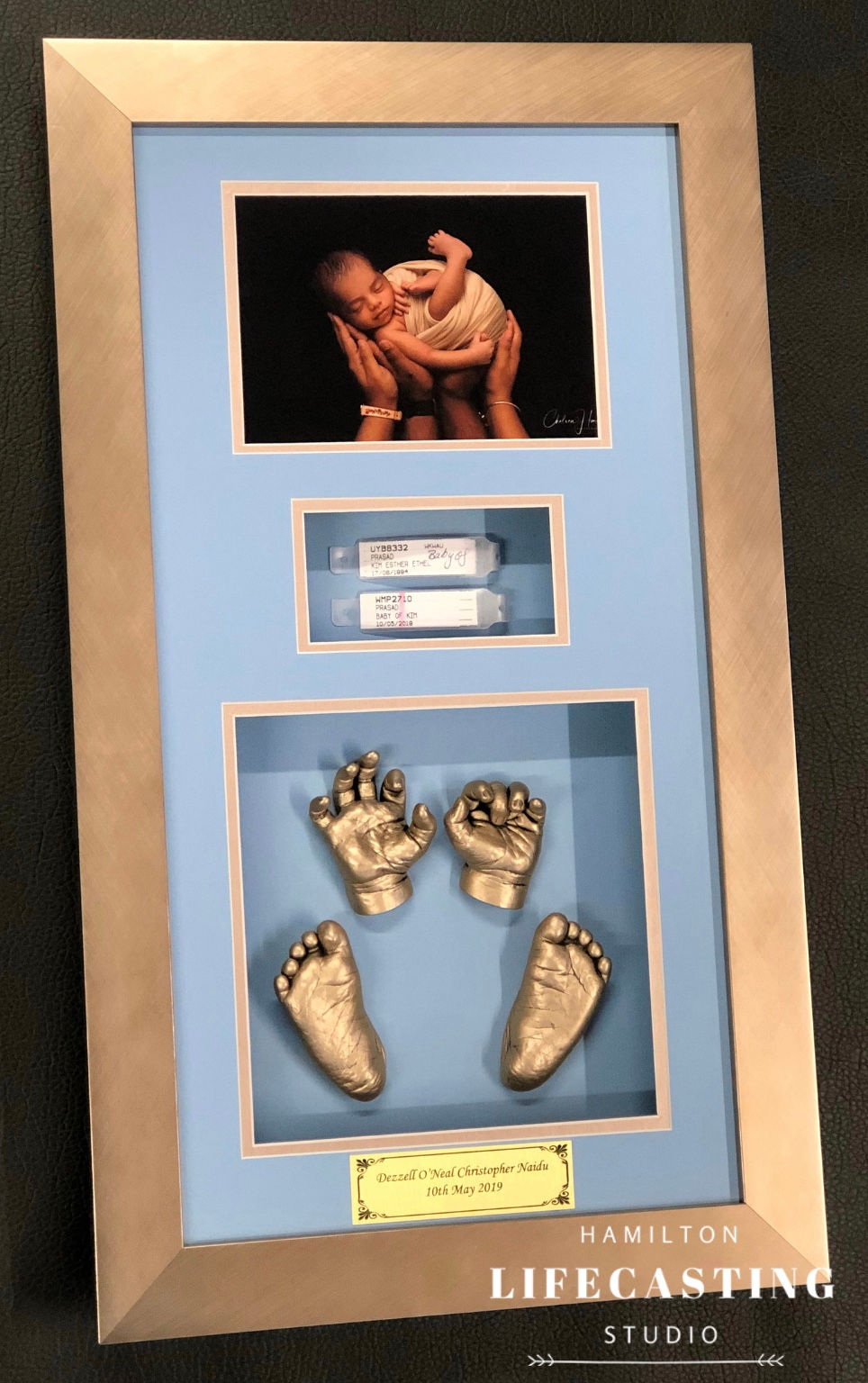 Baby profile on baby blue backdrop with bronze frame