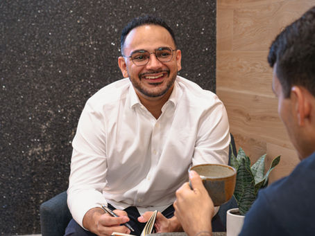 Person sitting in a therapy session with therapist, having a relaxed and open conversation, representing connection and trust in therapy