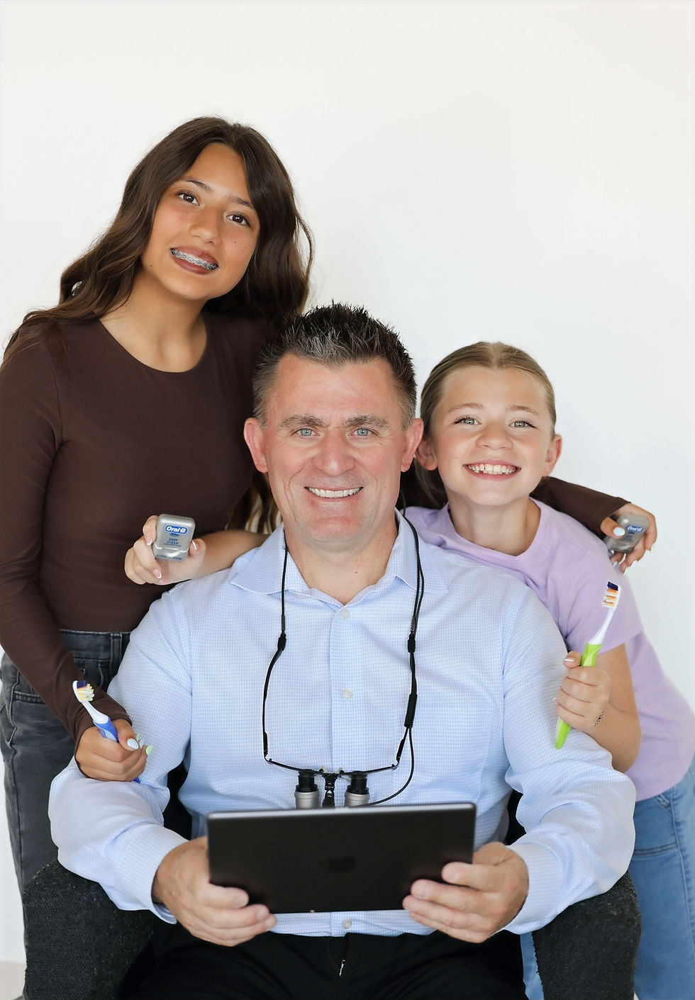 Smiling family dentist in Lincoln with two young patients