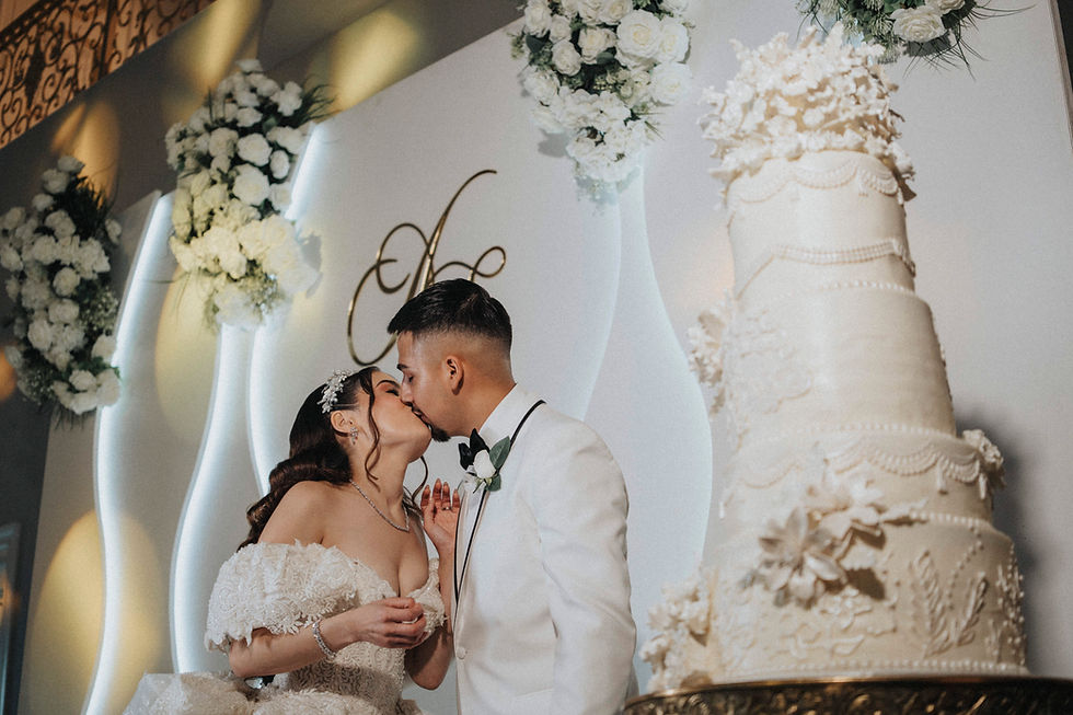 wedding day couple kiss, by cake