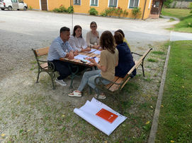 Gruppenarbeit im freien an einem Tisch im innen Hof