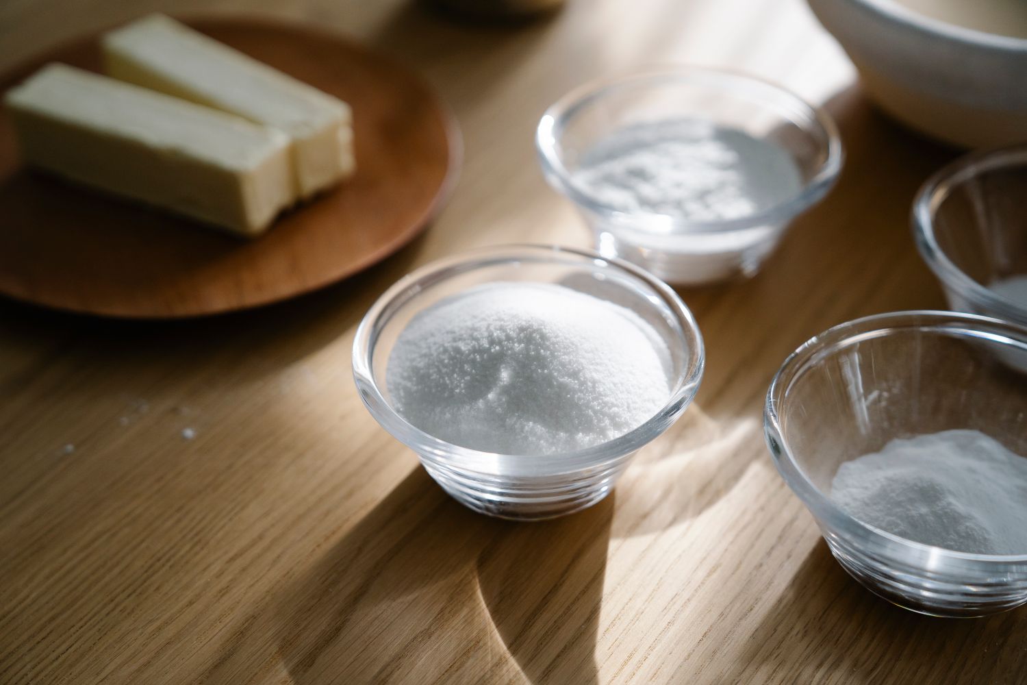 Poudre blanche de bicarbonate de soude versée d'une cuillère doseuse