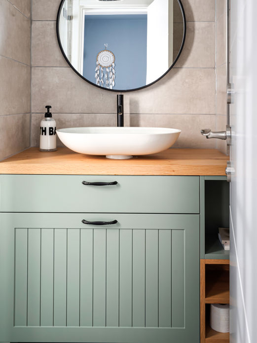 חדר רחצה מעוצב עם ארון וכיור מונח בגוונים של עץ וירוק מעושן