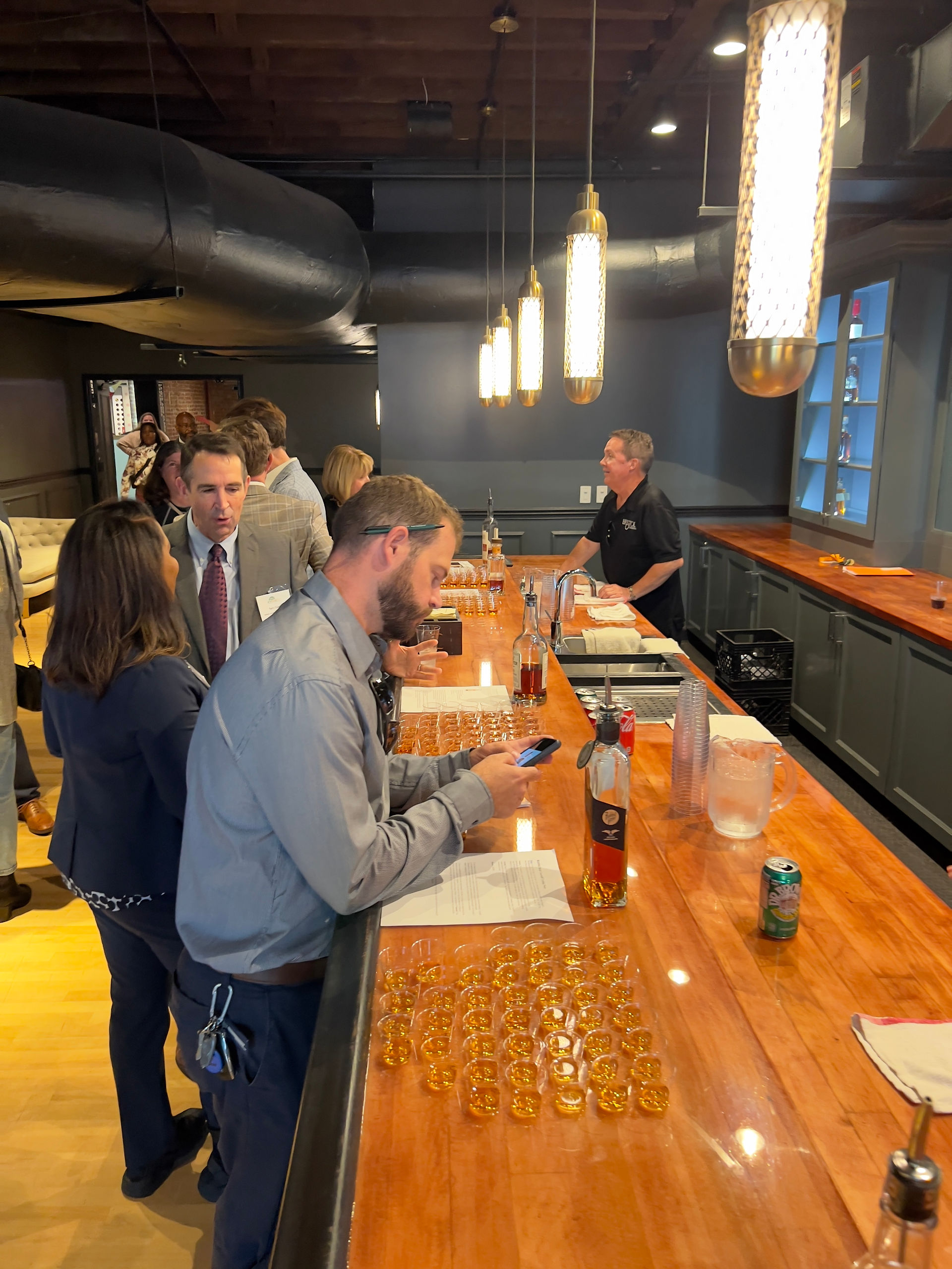 Attendees line up at bar for bourbon tasting