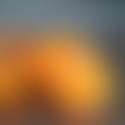 Two orange halves with seeds towards their centers on a variegated black marble counter.