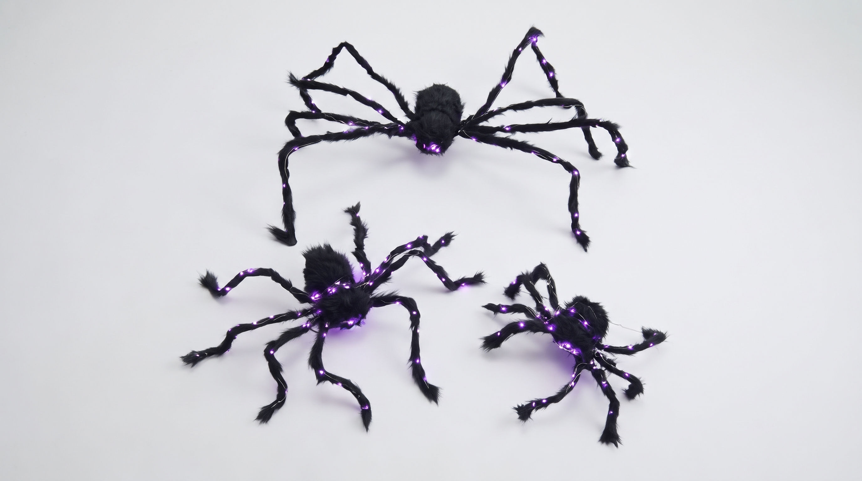 Aesthetic Halloween LED luminous plush spider casting a vibrant purple neon glowing eye display in the dark.