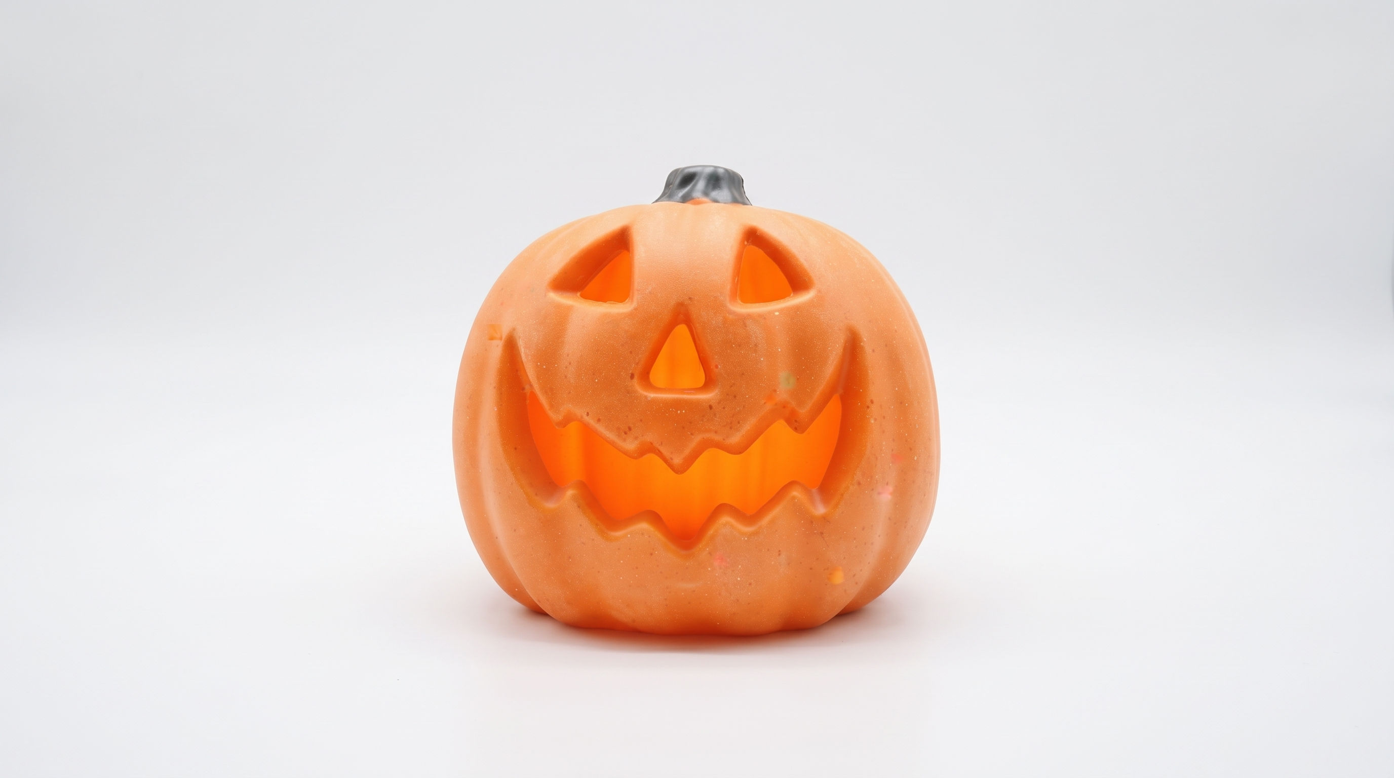 Aesthetic spooky hollow LED pumpkin lantern casting an intense traditional warm orange ambient glow.