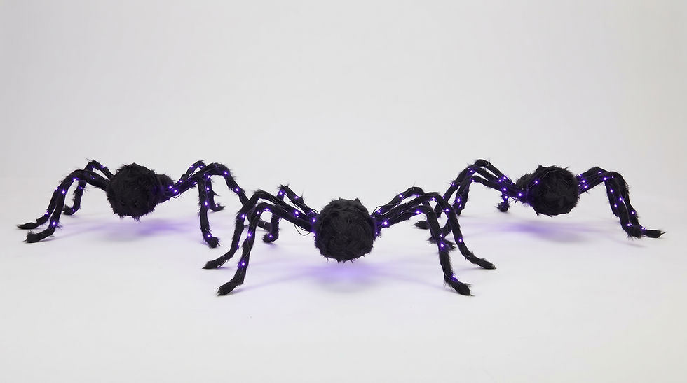 Giant black posable plush spider decoration attached to an indoor bedroom wall for modern room aesthetics.