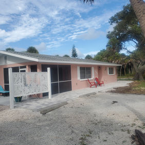 Fully repainted beach house exterior showing immaculate wood siding, a stained deck, and crisp window frames in Englewood, Florida by Best Paint Lines.