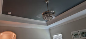 Freshly painted bedroom tray ceiling with immaculate white trim and modern lighting in Port Charlotte, Florida by Best Paint Lines.