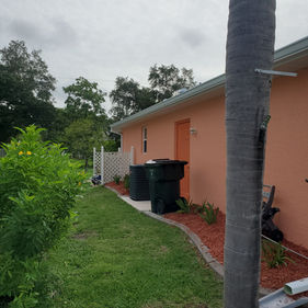 Stunning orange residential exterior paint job completed on a stucco home in Englewood, Florida.
