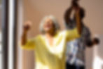 A joyful elderly couple dancing in the sunshine.