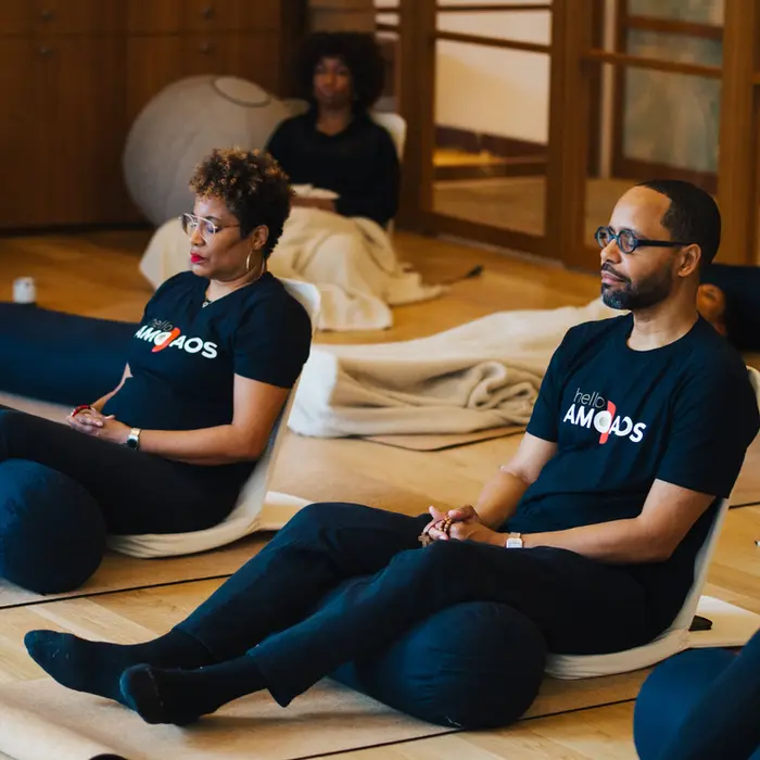 Individuals stretching and meditating at an AMODAOS event at the Smithsonian National Museum of African Art.