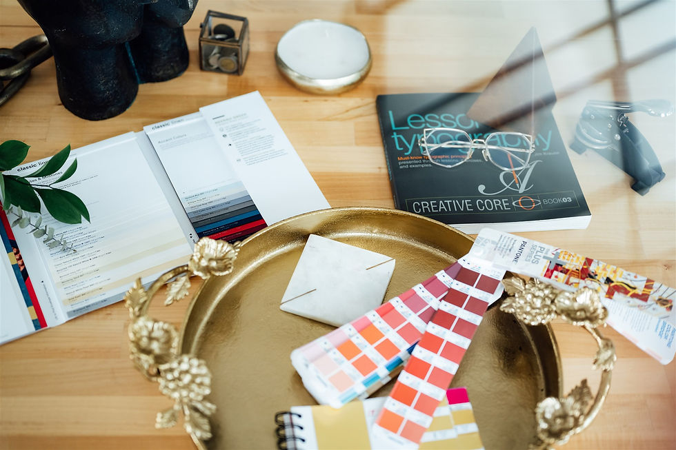 Atelier Oluwatosin brand image. Colour swatches and branding booklet scattered on a table.