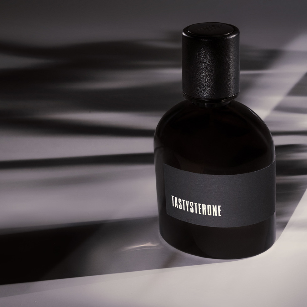 Tastyterone niche citrus perfume bottle in dramatic lighting.