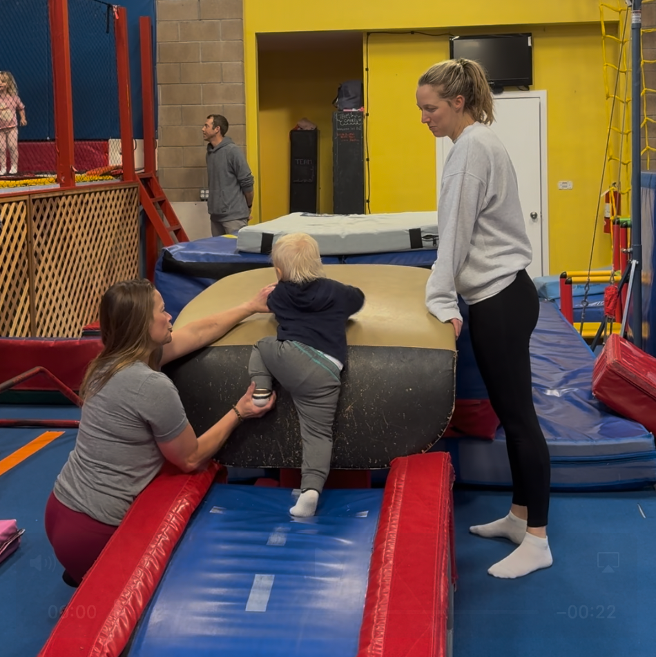Close-up view of toddler climbing a soft play structure in a gym