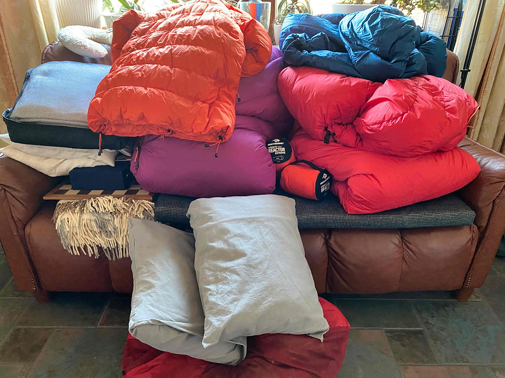 Sofa voller Daunenkleidung und -schlafsäcke