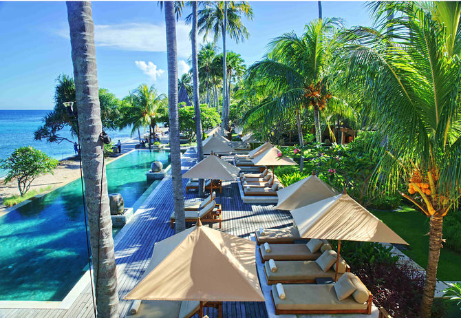 Traumhafter Blick auf den Pool und Gartenanlage eines Hotels auf der indonesischen Insel Lombok vor Bali.