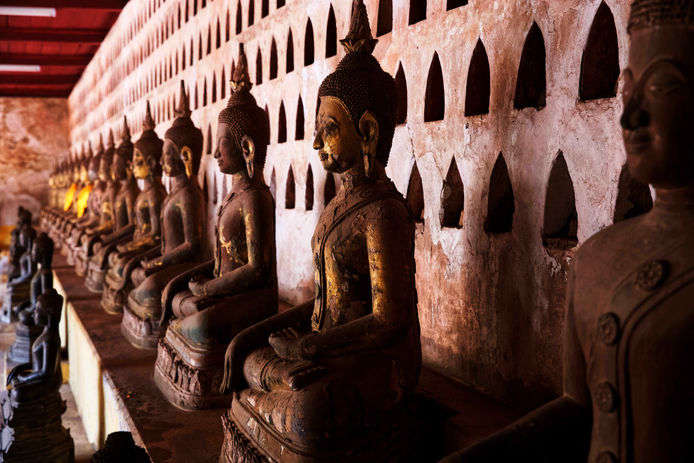 Eine Reihe von Buddha Statuen in einem Tempel der laotischen Hauptstadt Vientiane.