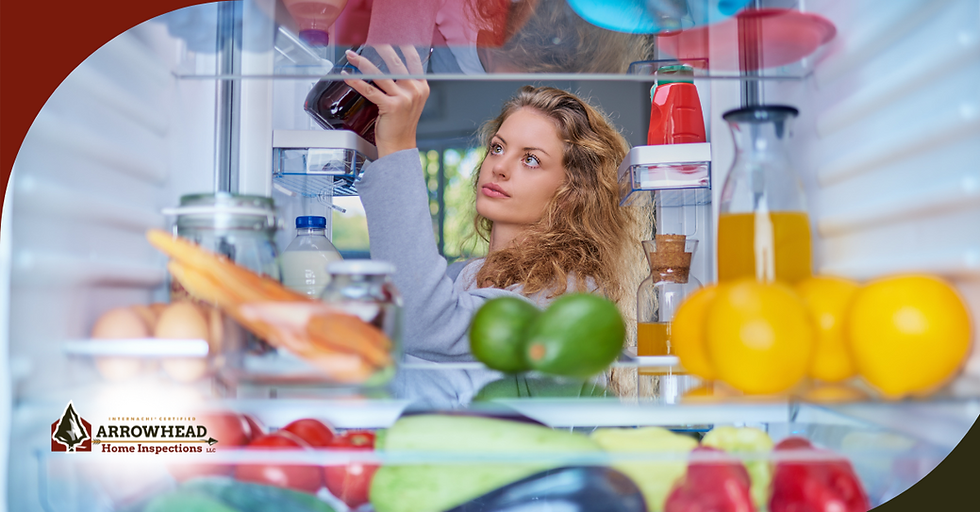Woman reaching for a bottle in the refrigerator filled with fruits and drinks.