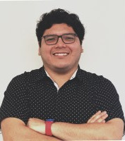 Smiling man wearing glasses and a dark shirt, arms crossed