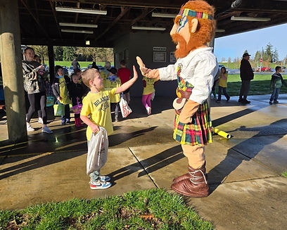 Haymitch the Highlander giving a high five to a Hilander Hustle Particpant