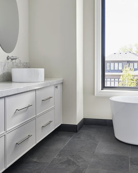 Modern white bathroom cabinetry and freestanding bathtub